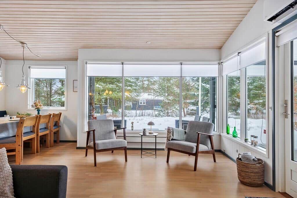 Large living room with hardwood floors and windows overlooking snow.