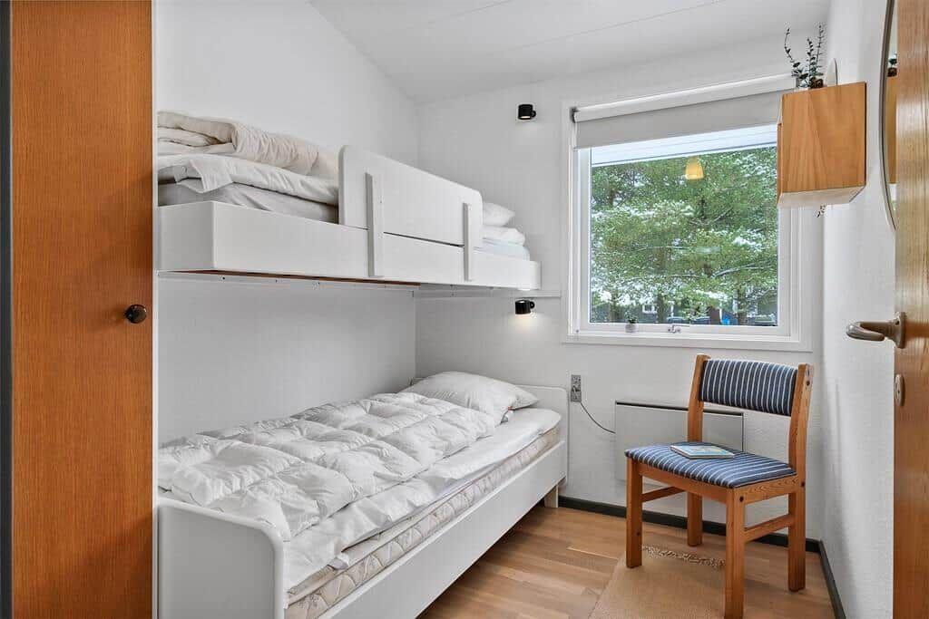 Room with bunk bed and chair by window