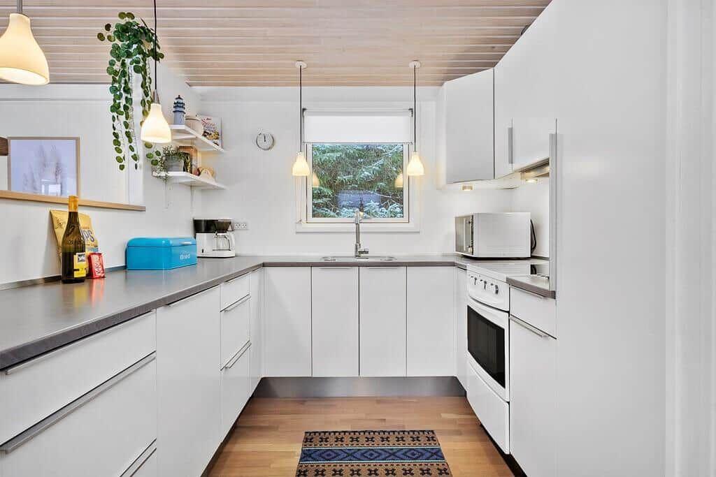 Kitchen with white cabinets, countertop, and window.