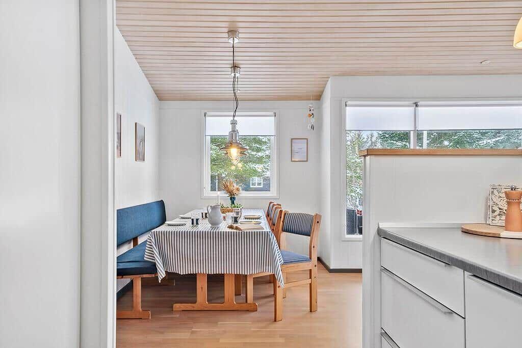 Dining area with table, chairs, and windows for views.