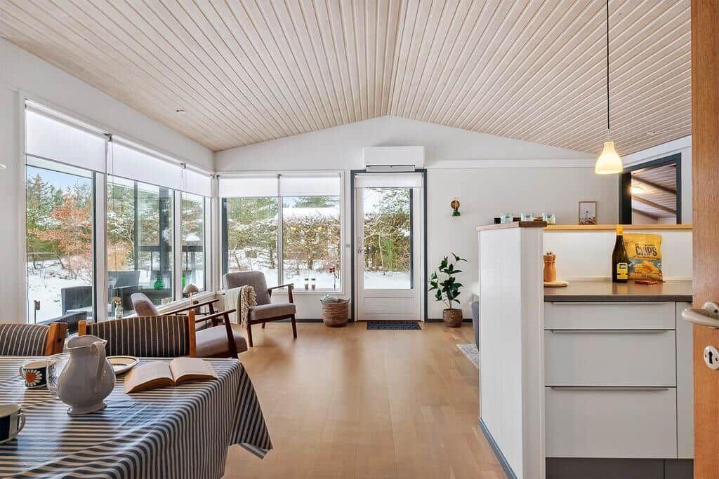 Living area with dining space, kitchen, and large window view of snow.