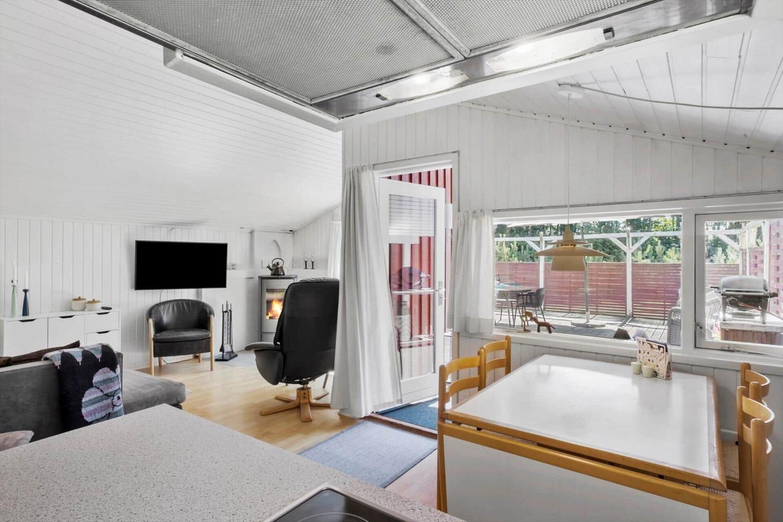 Living and dining area with fireplace, TV, and terrace