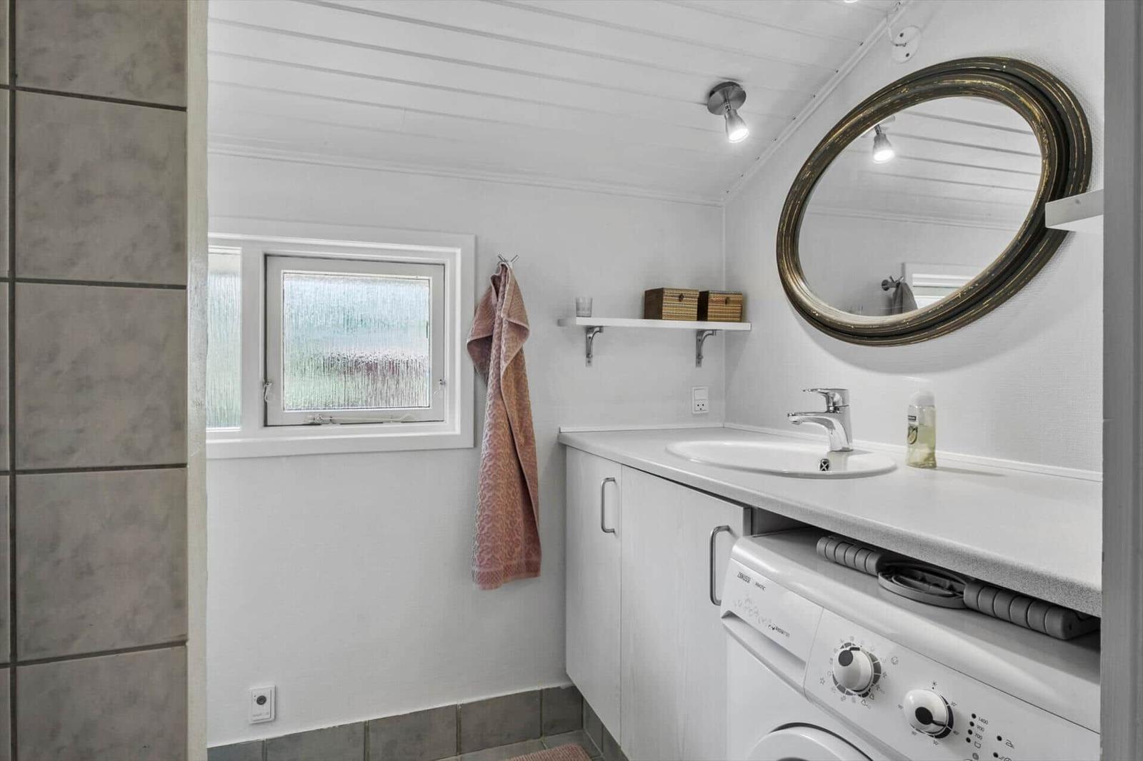 Bathroom with washing machine, mirror, and window