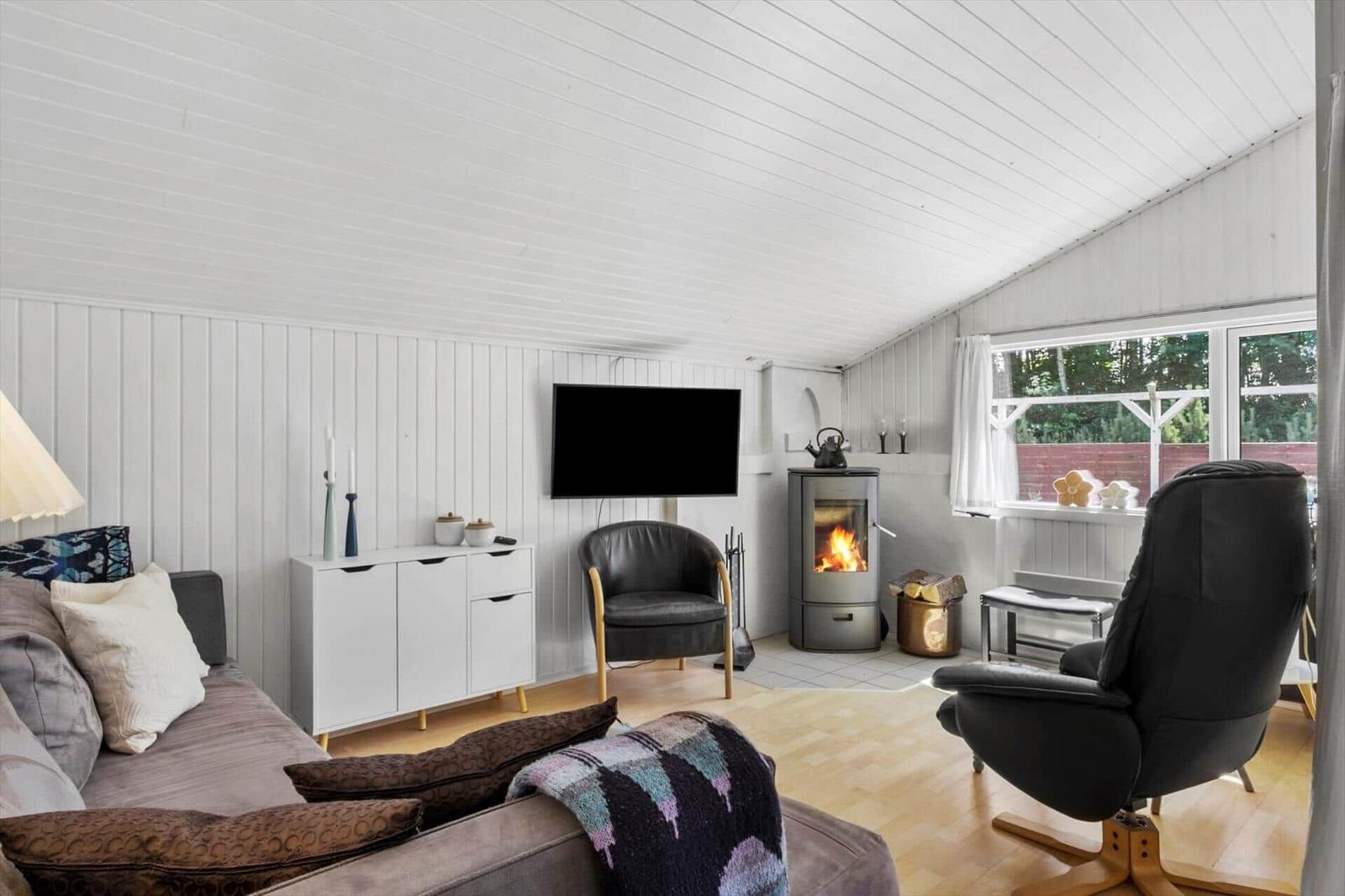 Living room with fireplace, sofa, TV, and armchairs.