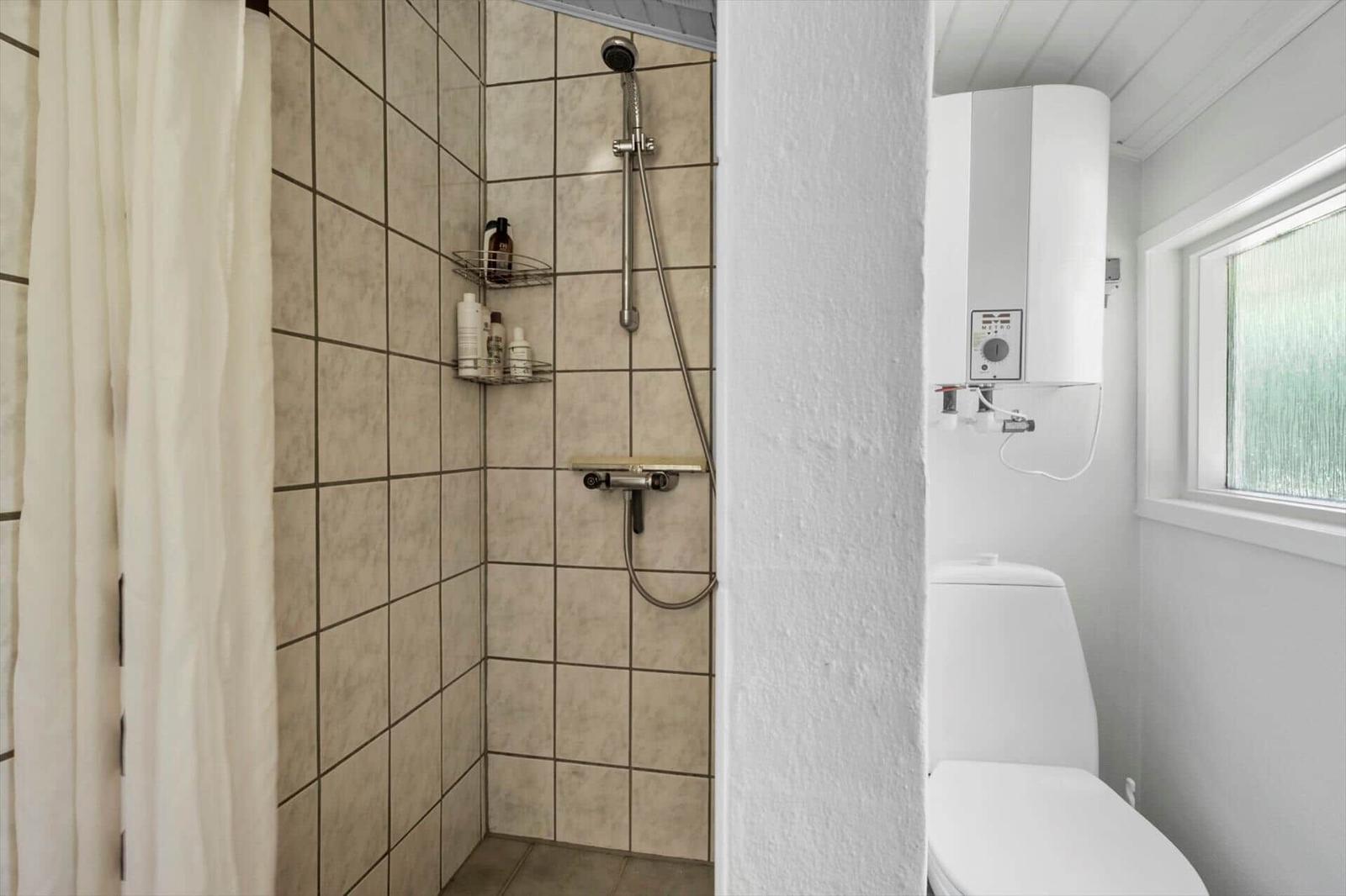 Bathroom with shower, toilet, and window