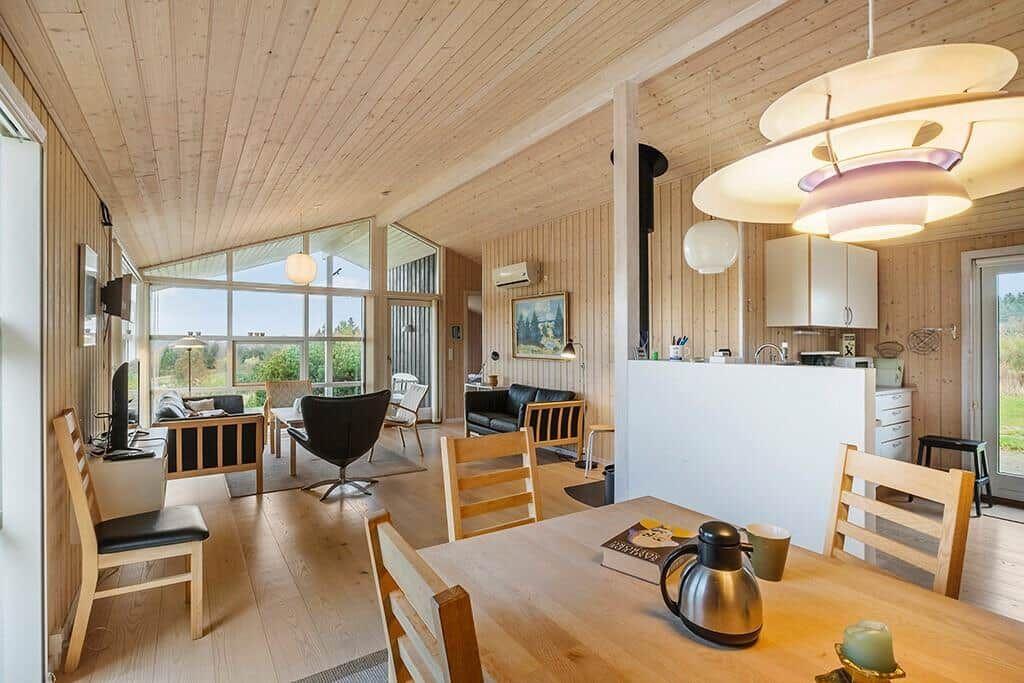 Living and dining area with wood paneling and modern lighting.