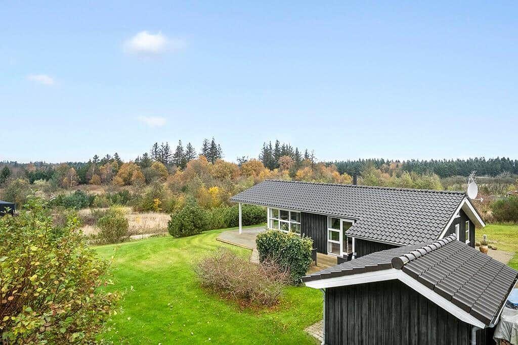 House with garden and forest view. Wooden house with terrace and satellite dish.
