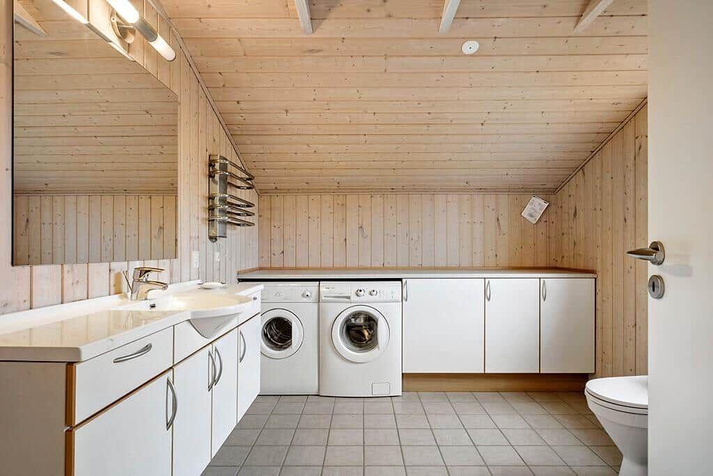 Bathroom with washing machine, dishwasher, and toilet