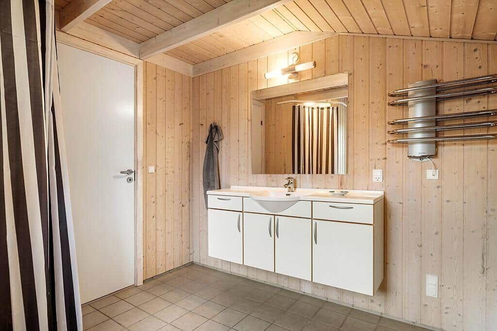 Bathroom with wooden walls, sink, and heater