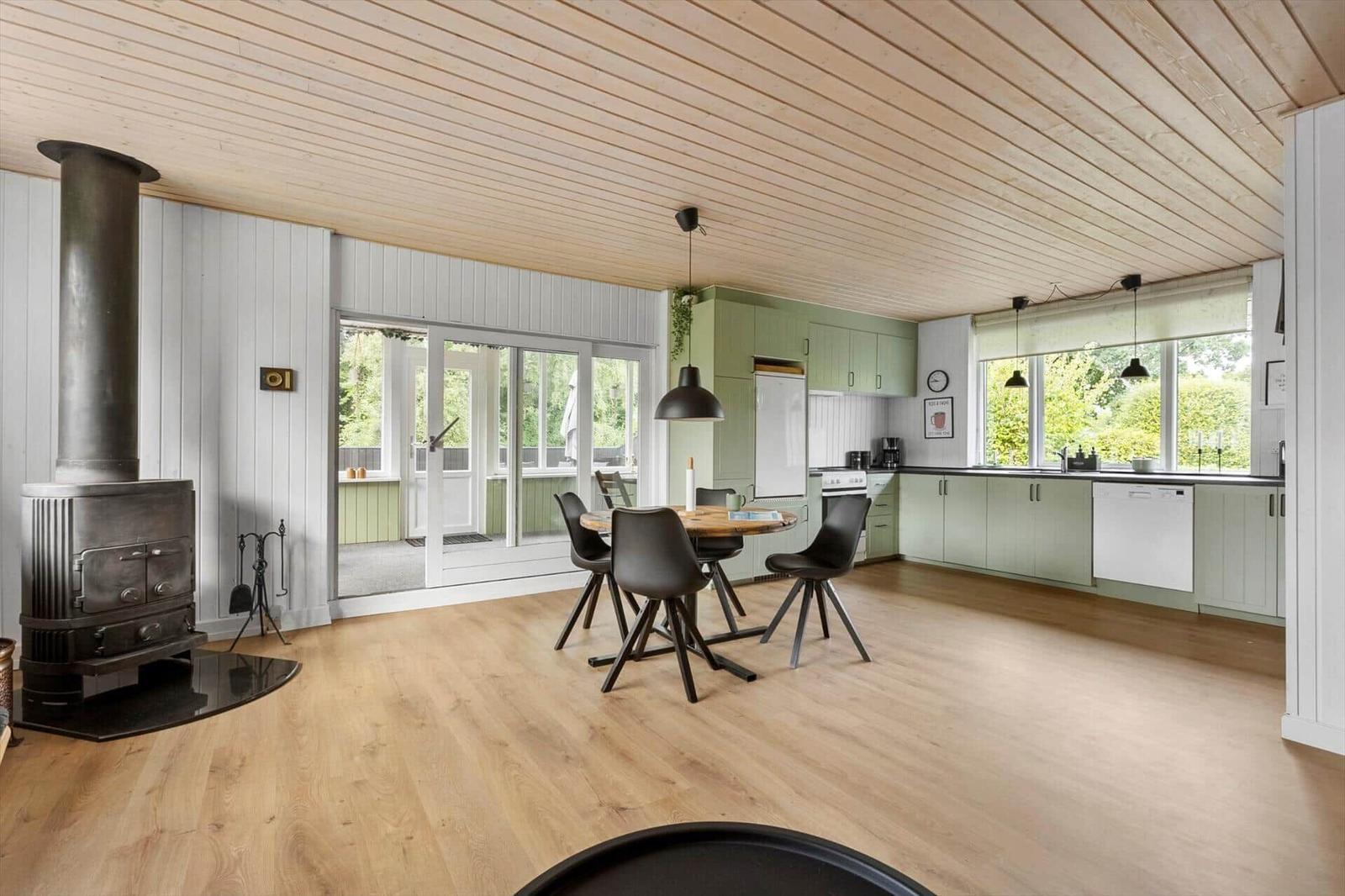 Kitchen with dining table, wooden floor, and wooden ceiling. Access to terrace.