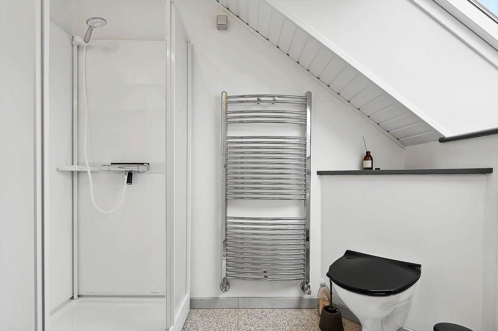 Dusche, Heizung und Toilette in einem Dachbodenbad.