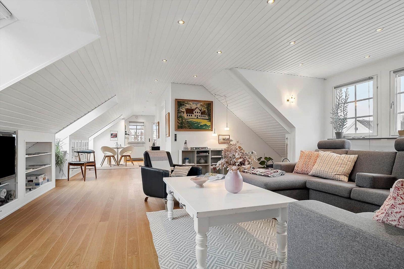 Wohn- und Essbereich mit Holzboden, Sofa und Fernseher