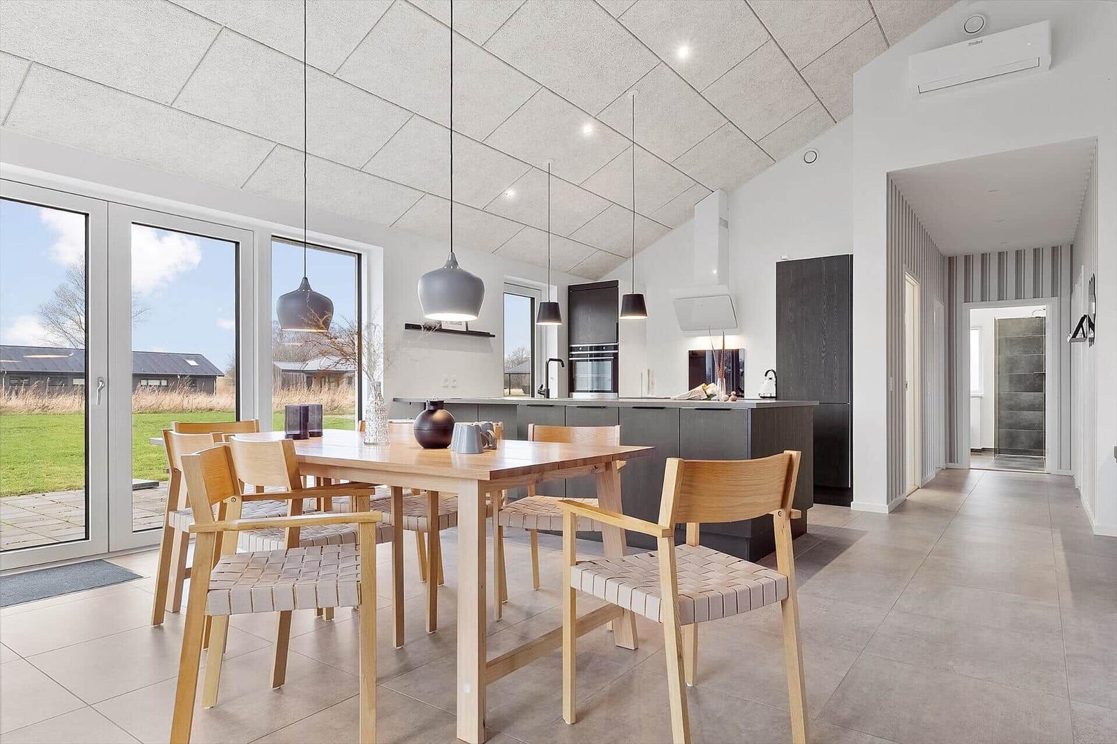 Moderne Küche mit Essbereich und großem Fensterblick auf die Landschaft.