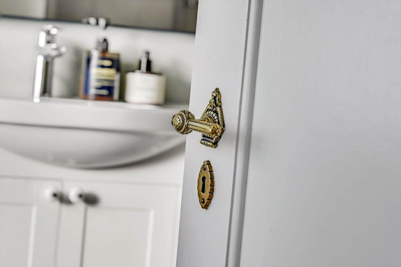 Tür mit goldenem Griff und Schlüsselloch im Badezimmer