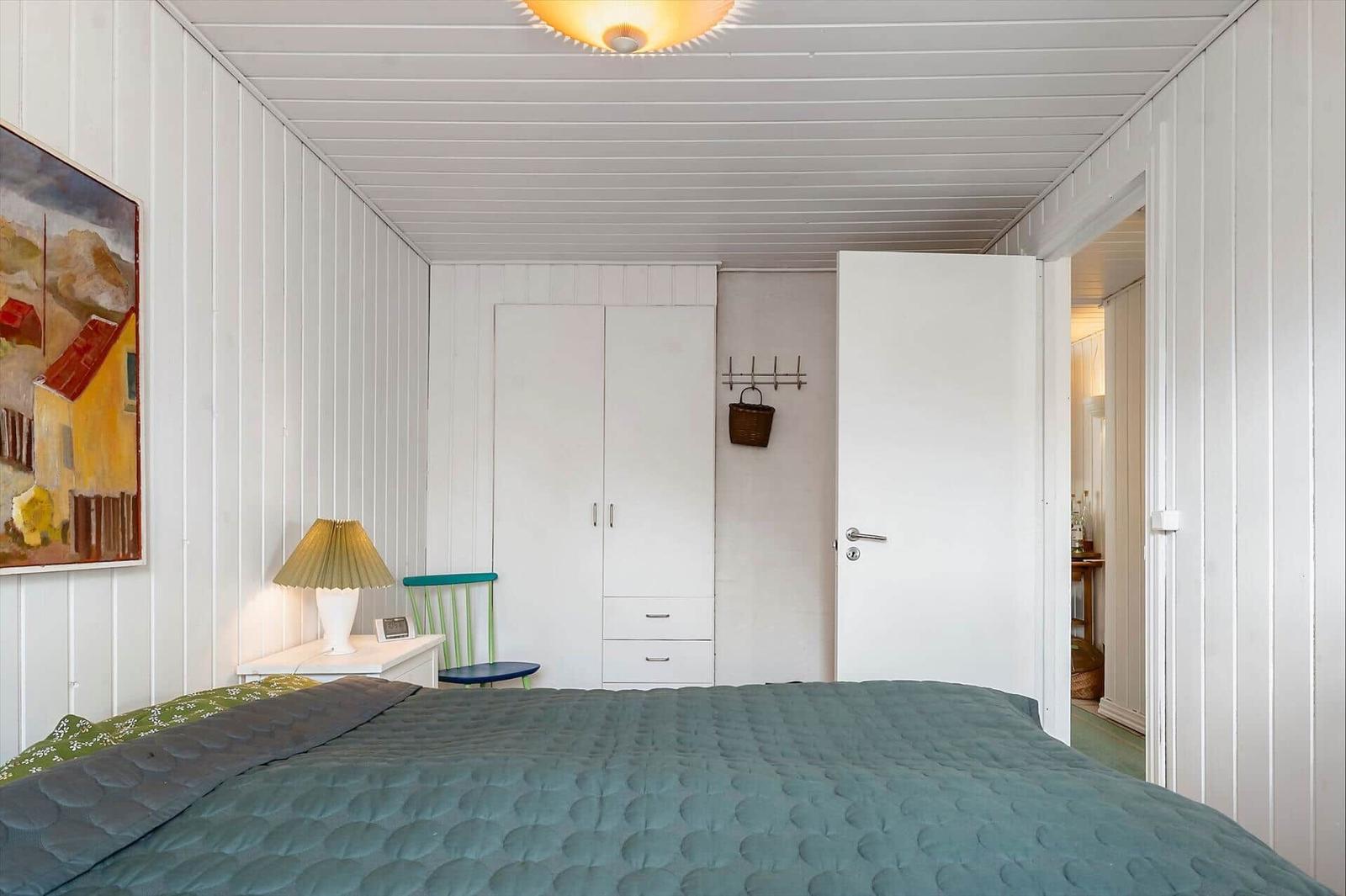 Bedroom with bed, wardrobe, and lamps