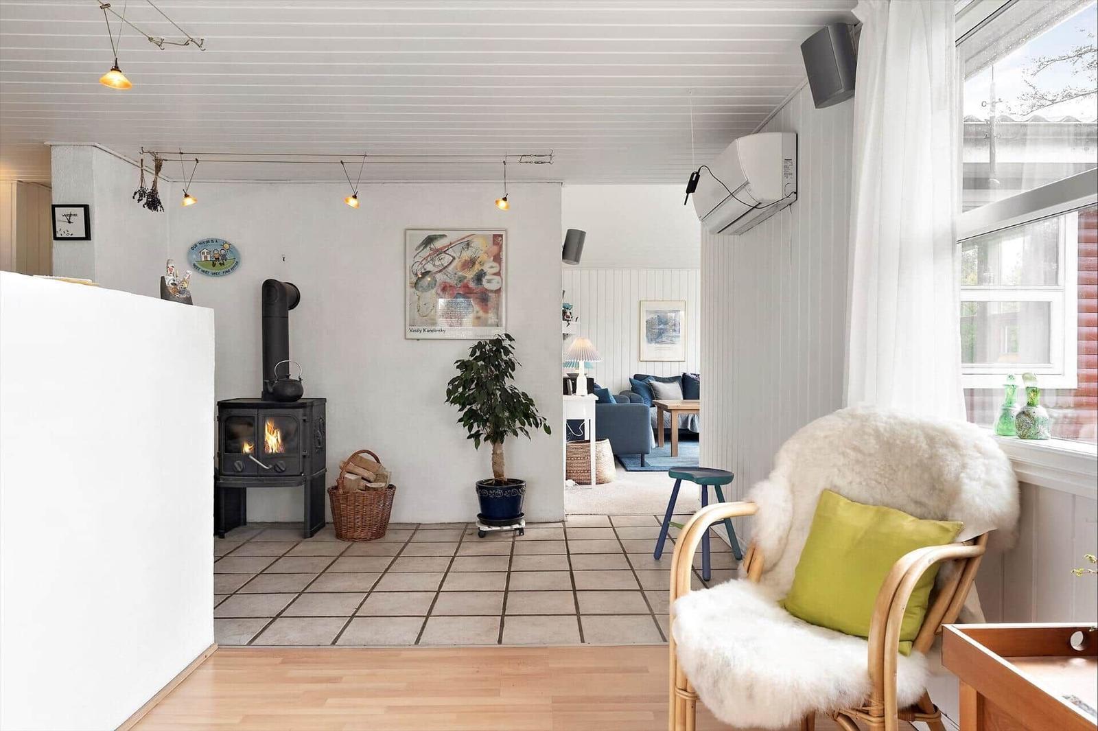 Room with fireplace, plant, and seating near window.