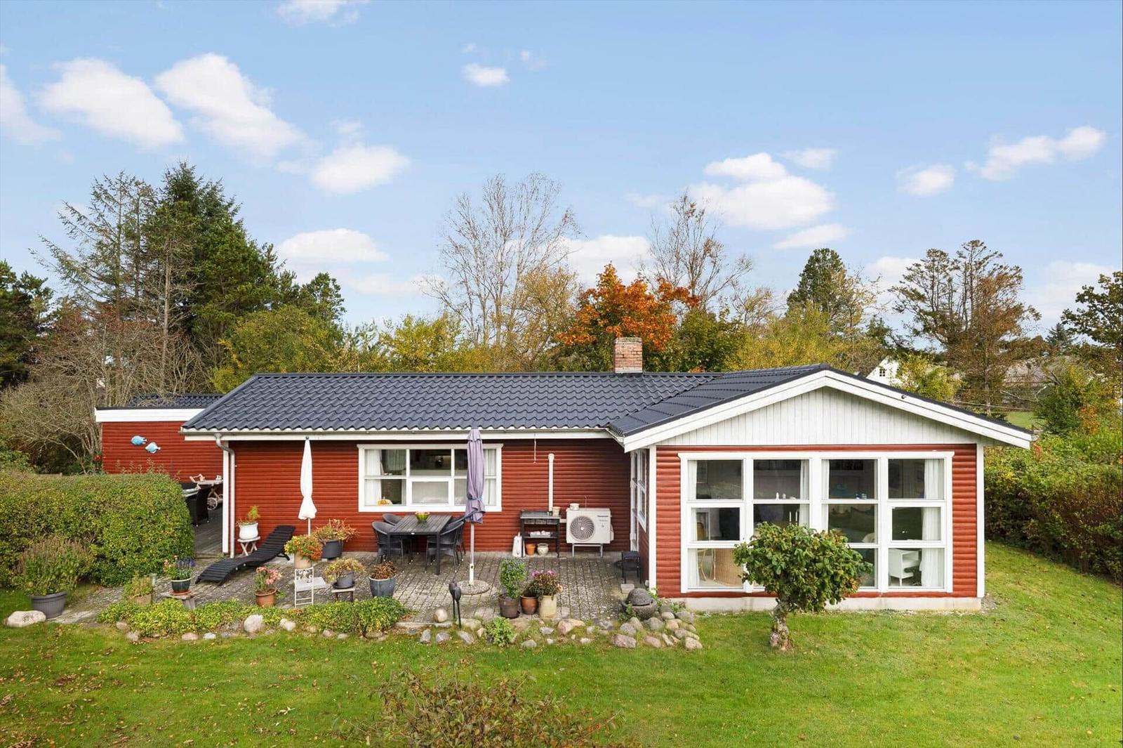 Red house with terrace and garden. Grill area and seating.