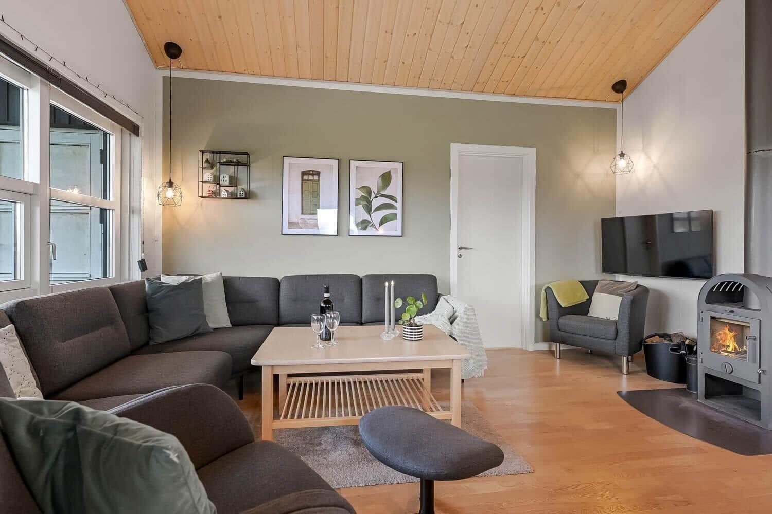 Wohnzimmer mit Sofa, Kamin und Fernseher.