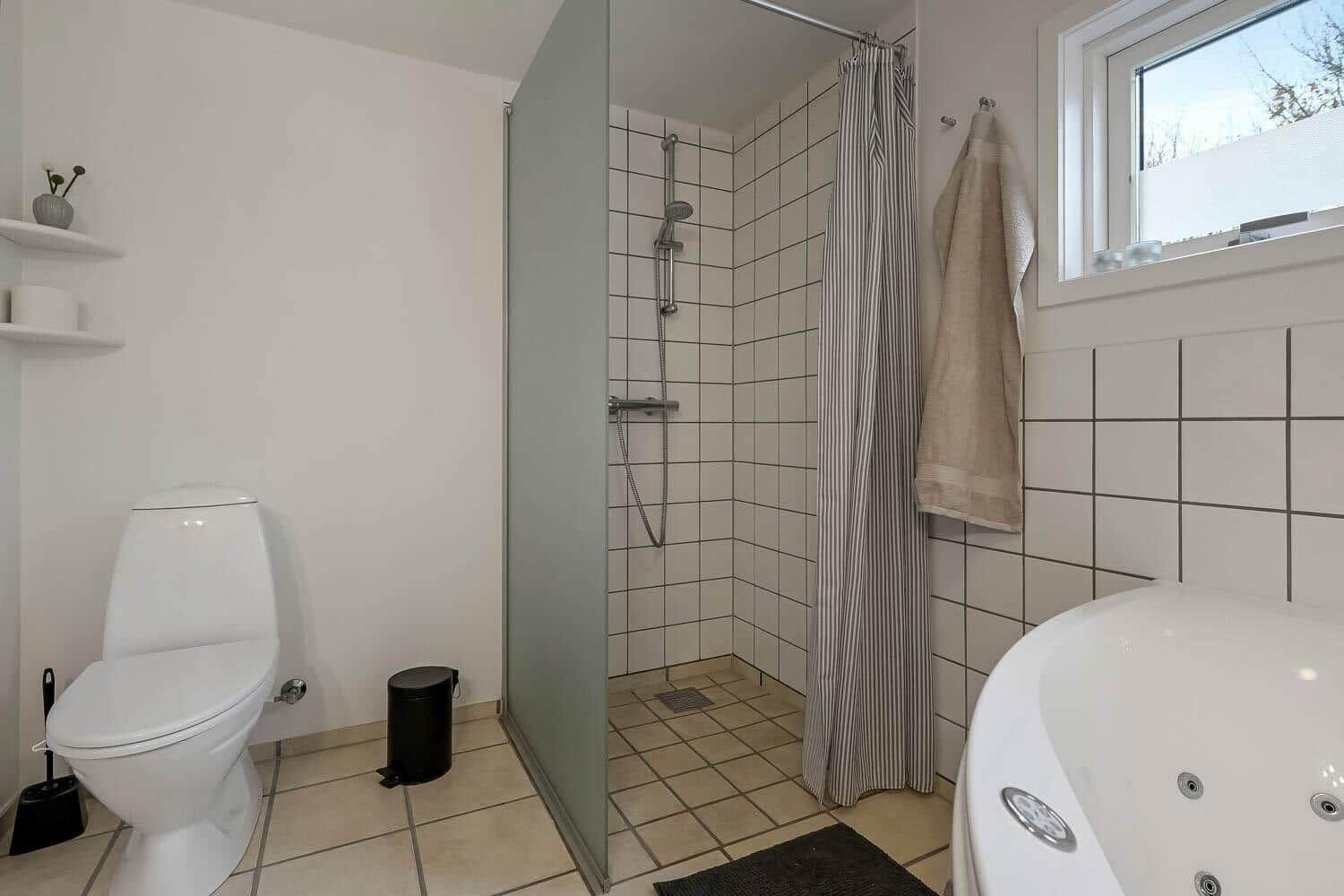 Badezimmer mit Dusche, Badewanne und Toilette.