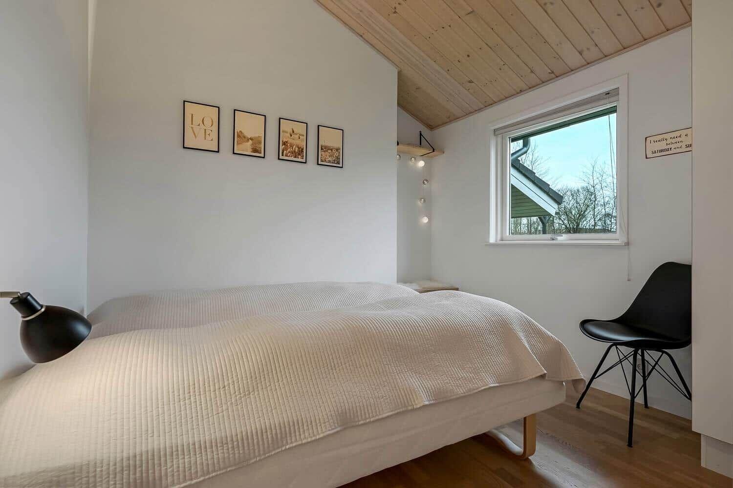 Schlafzimmer mit Bett, Fenster und Stuhl