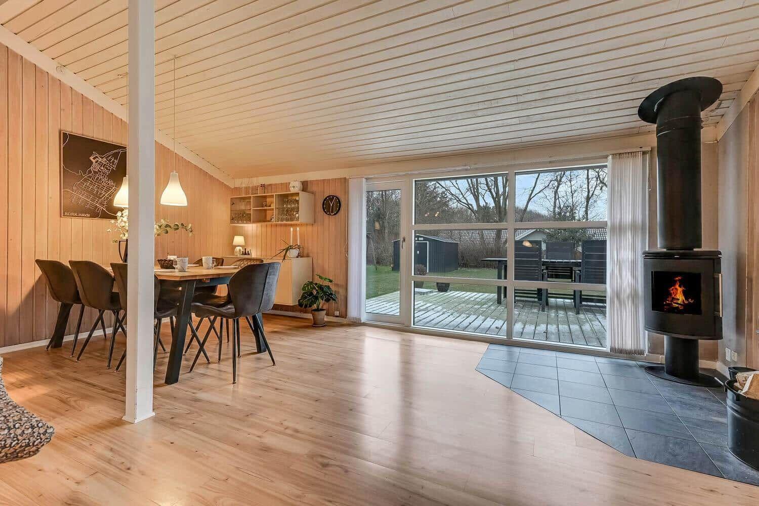Großes Wohnzimmer mit Esstisch, Kamin und Terrasse