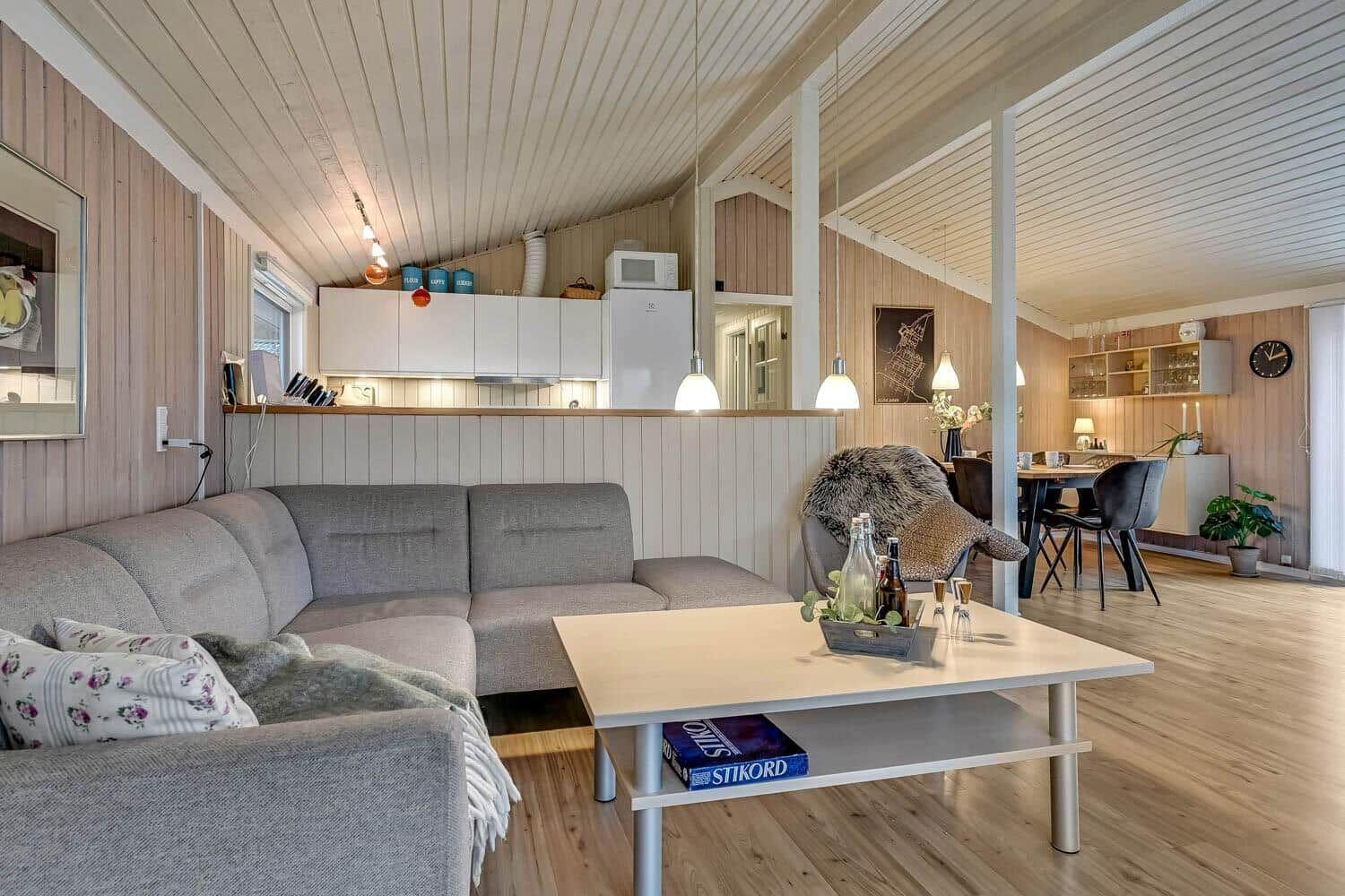 Wohn- und Essbereich mit Sofa, Tisch und Küchenzeile.