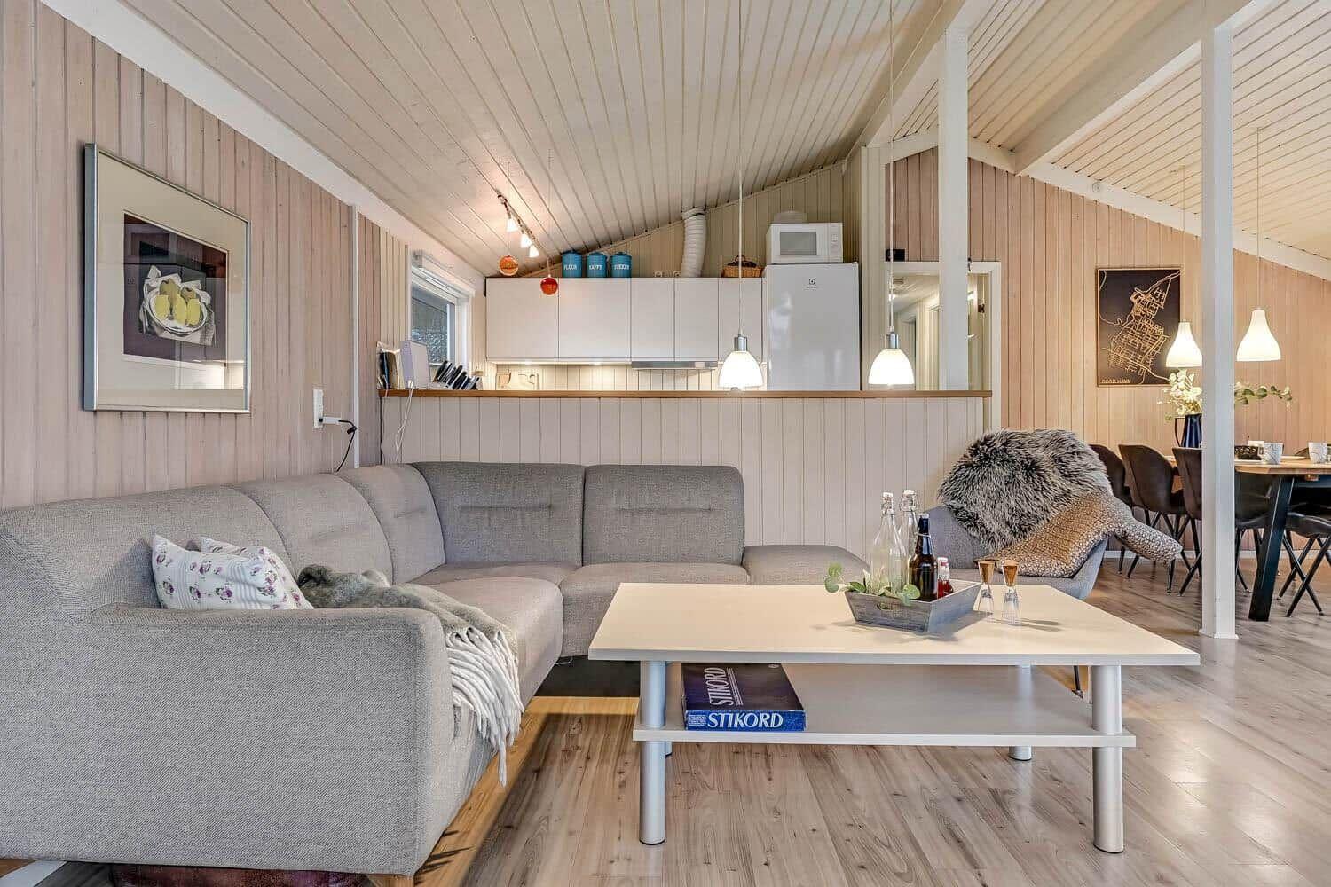 Wohnzimmer mit Sofa, Couchtisch und Küchenbereich im Hintergrund.