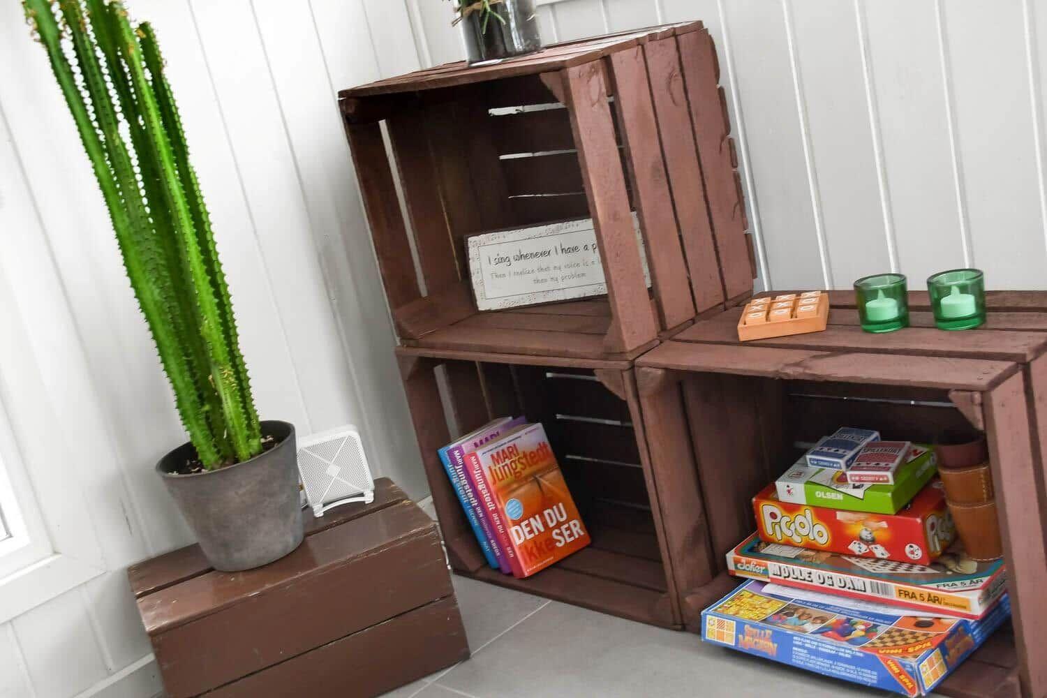 Holzregale mit Büchern, Spielen und einer Pflanze.
