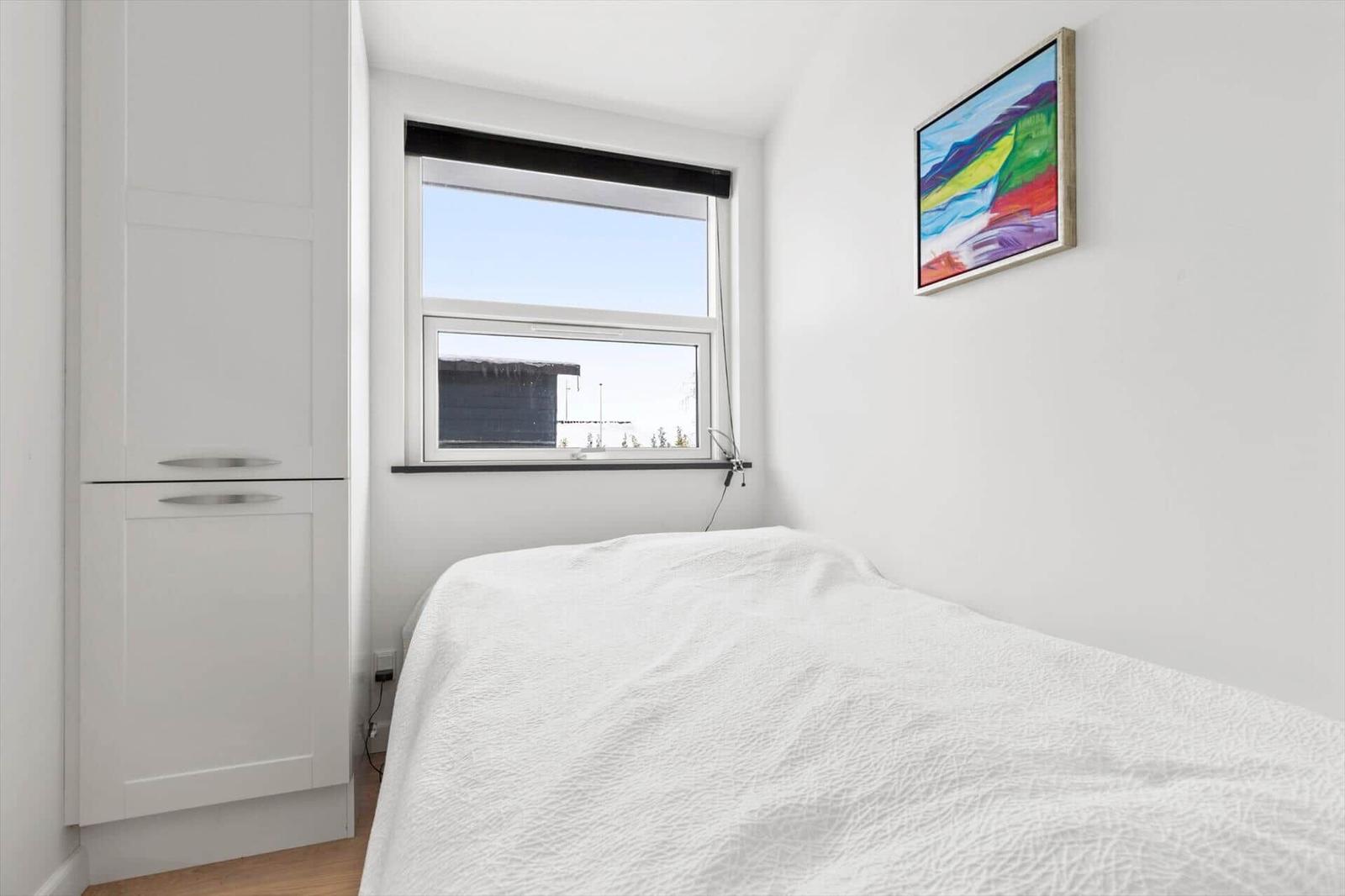 Bedroom with bed, window, and wall art.
