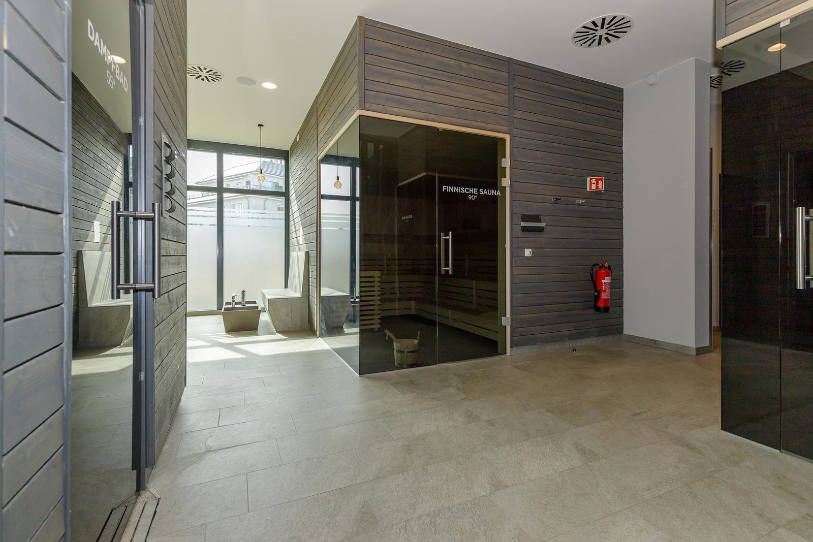 Finnische Sauna und Dampfbad mit Holzwand und Glasfront