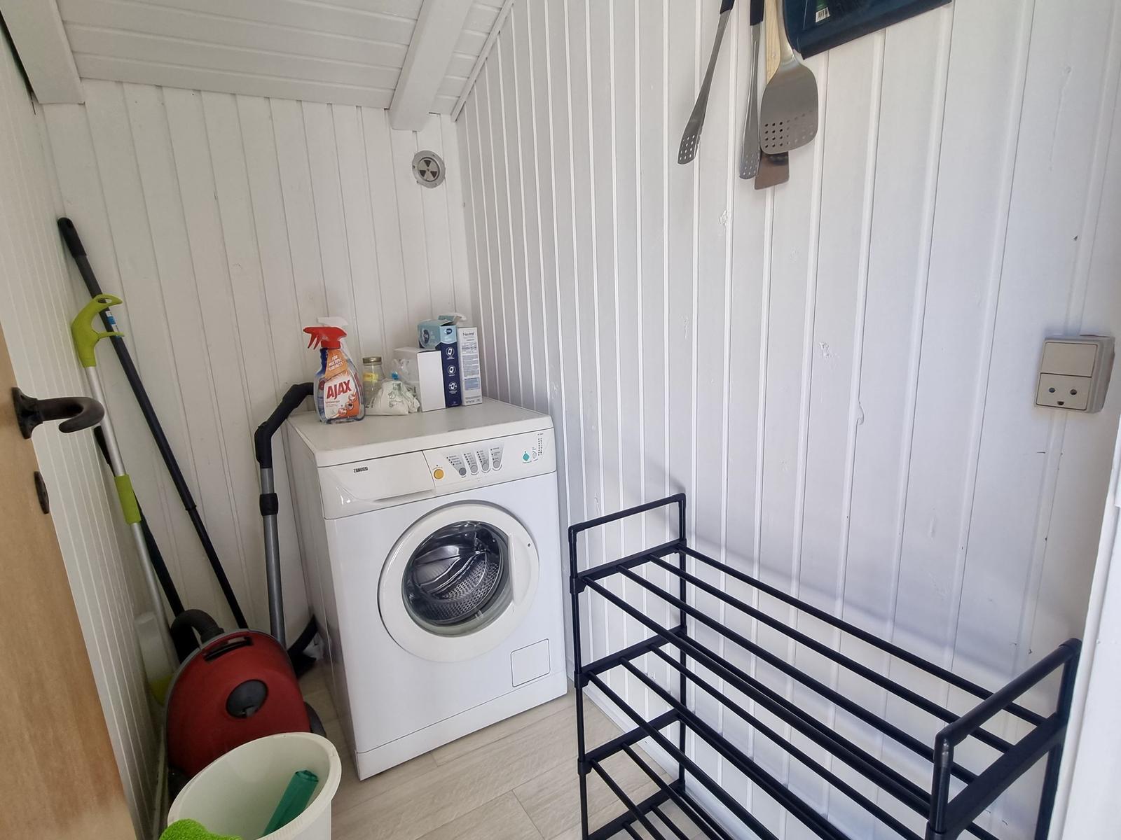 Wäscherei mit Waschmaschine, Trockner und Reinigungsmitteln.