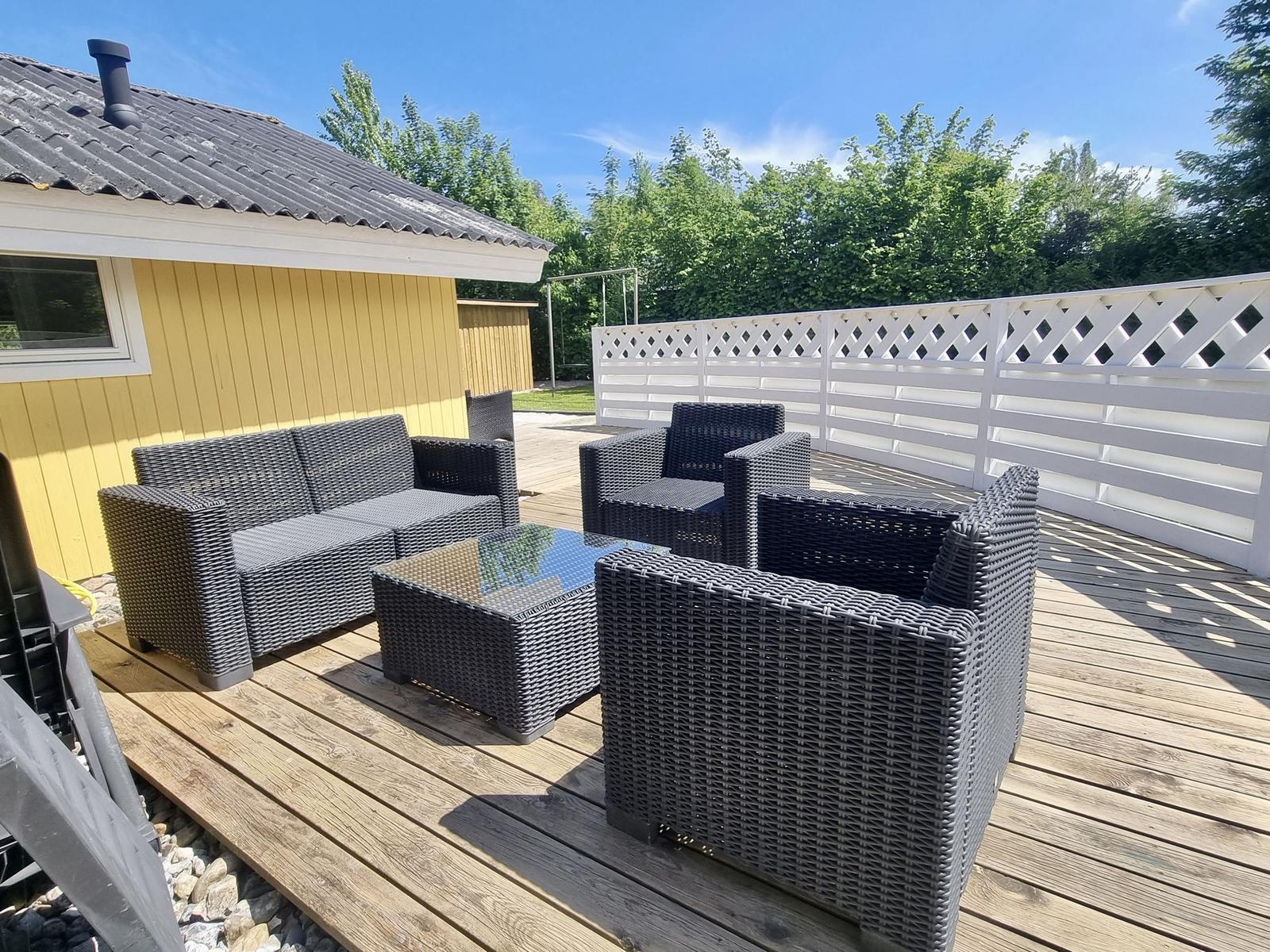 Terrasse mit Sitzgruppe, Holzboden und weißer Umzäunung