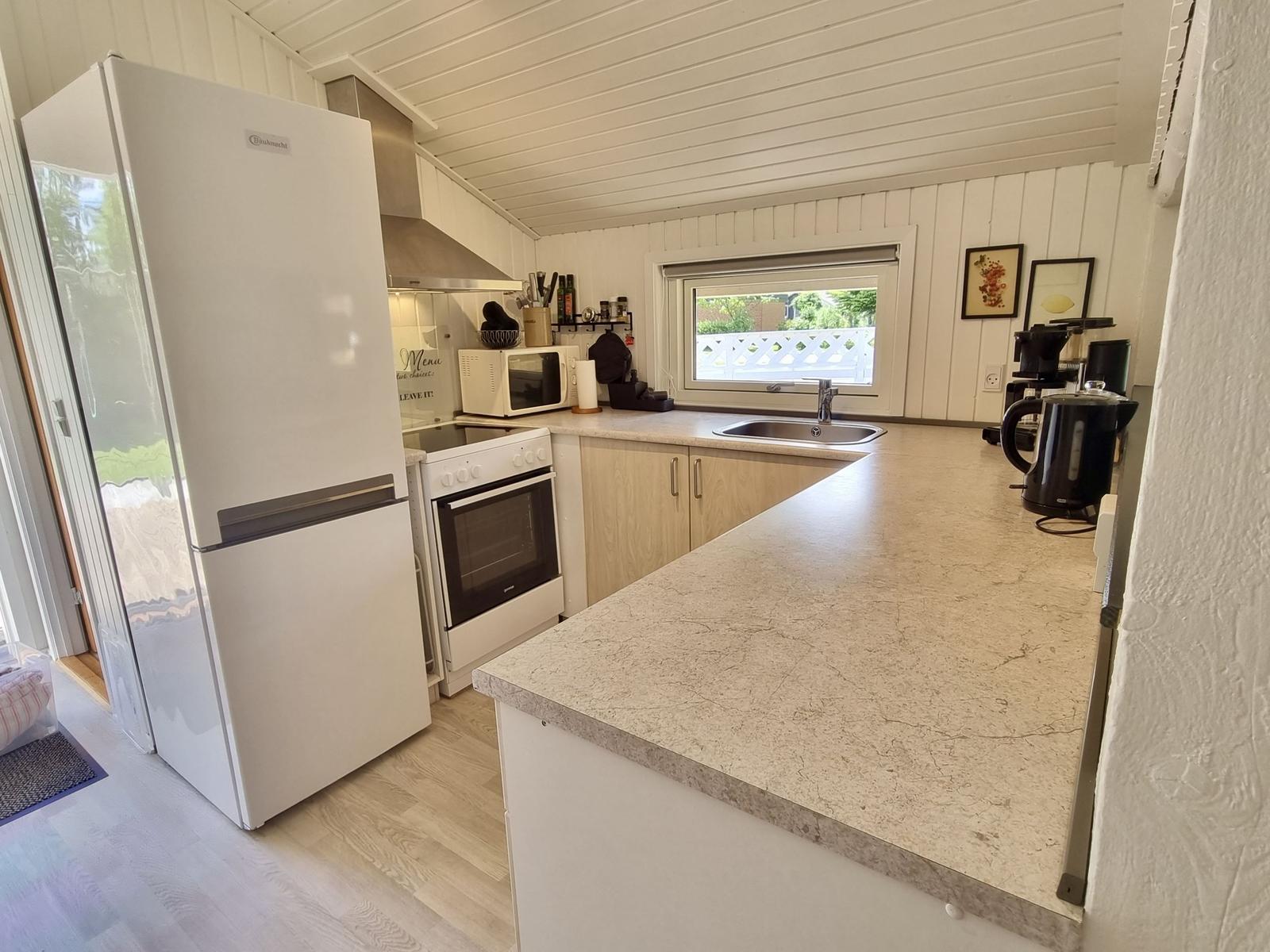 Küche mit Kühlschrank, Herd und Arbeitsfläche