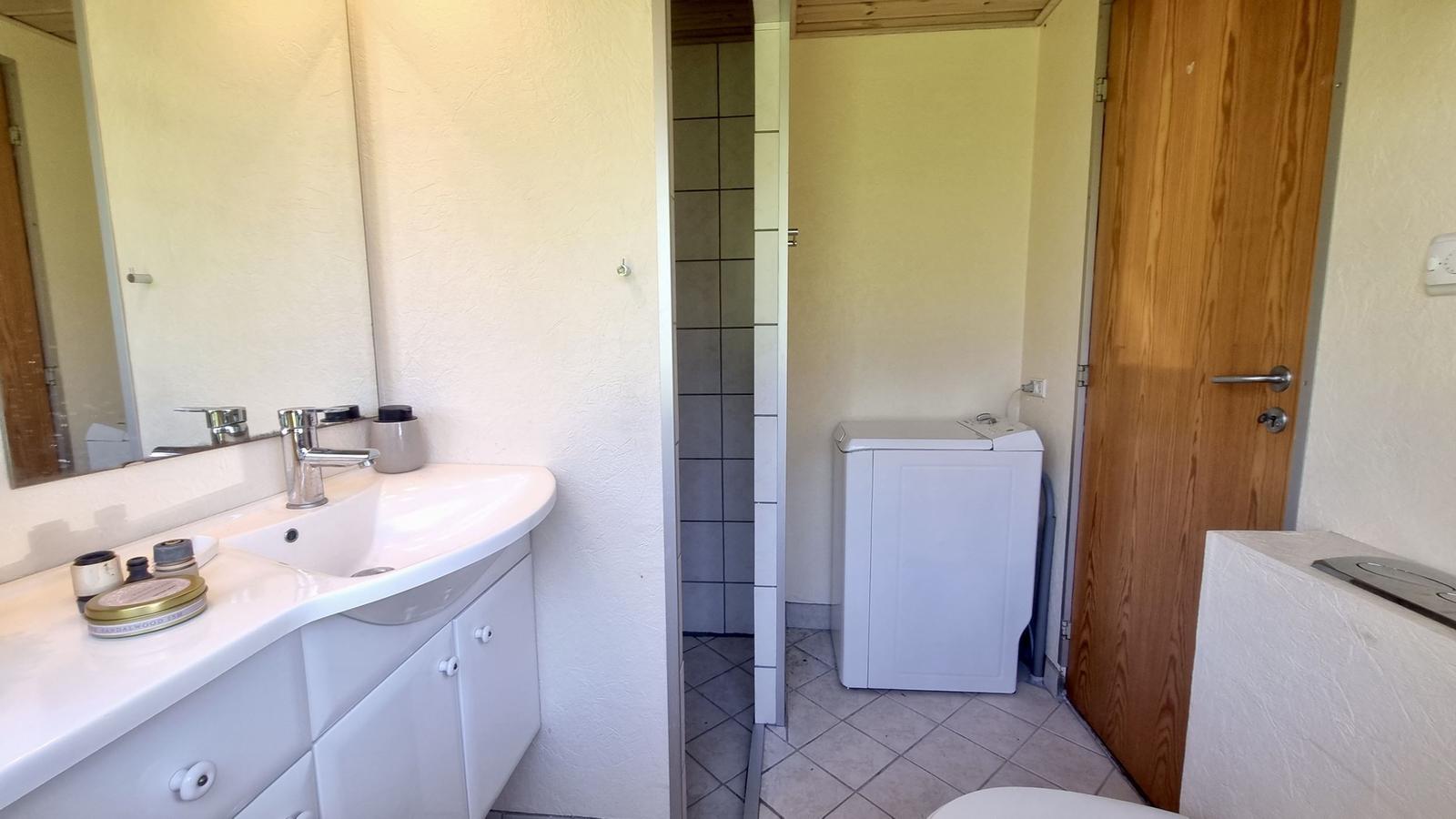 Bad mit Waschbecken, Spiegel und Waschmaschine