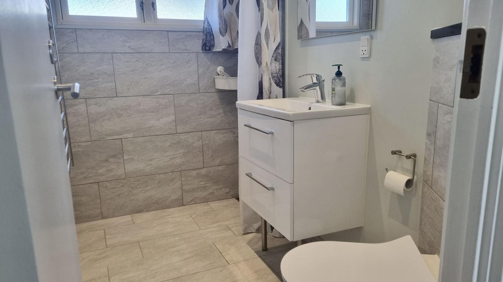 Badezimmer mit Waschbecken, Toilette und Dusche.