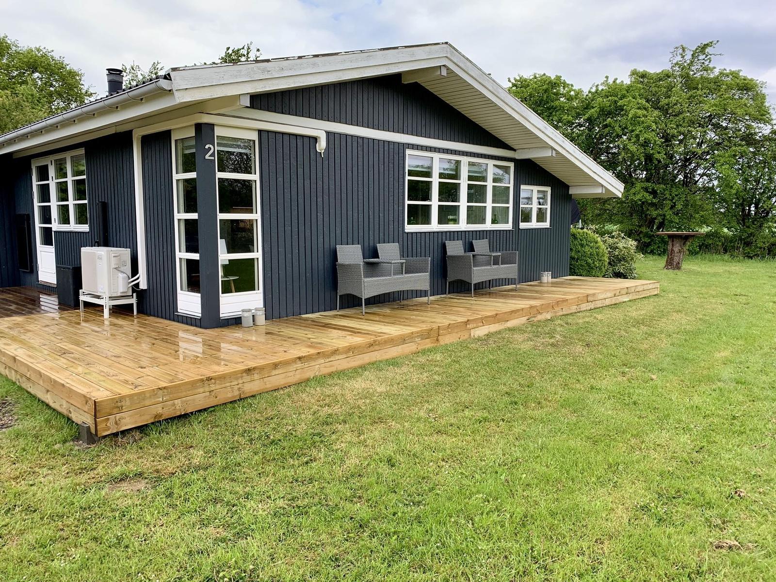 Haus mit Holzterrasse, Garten und Sitzgelegenheiten