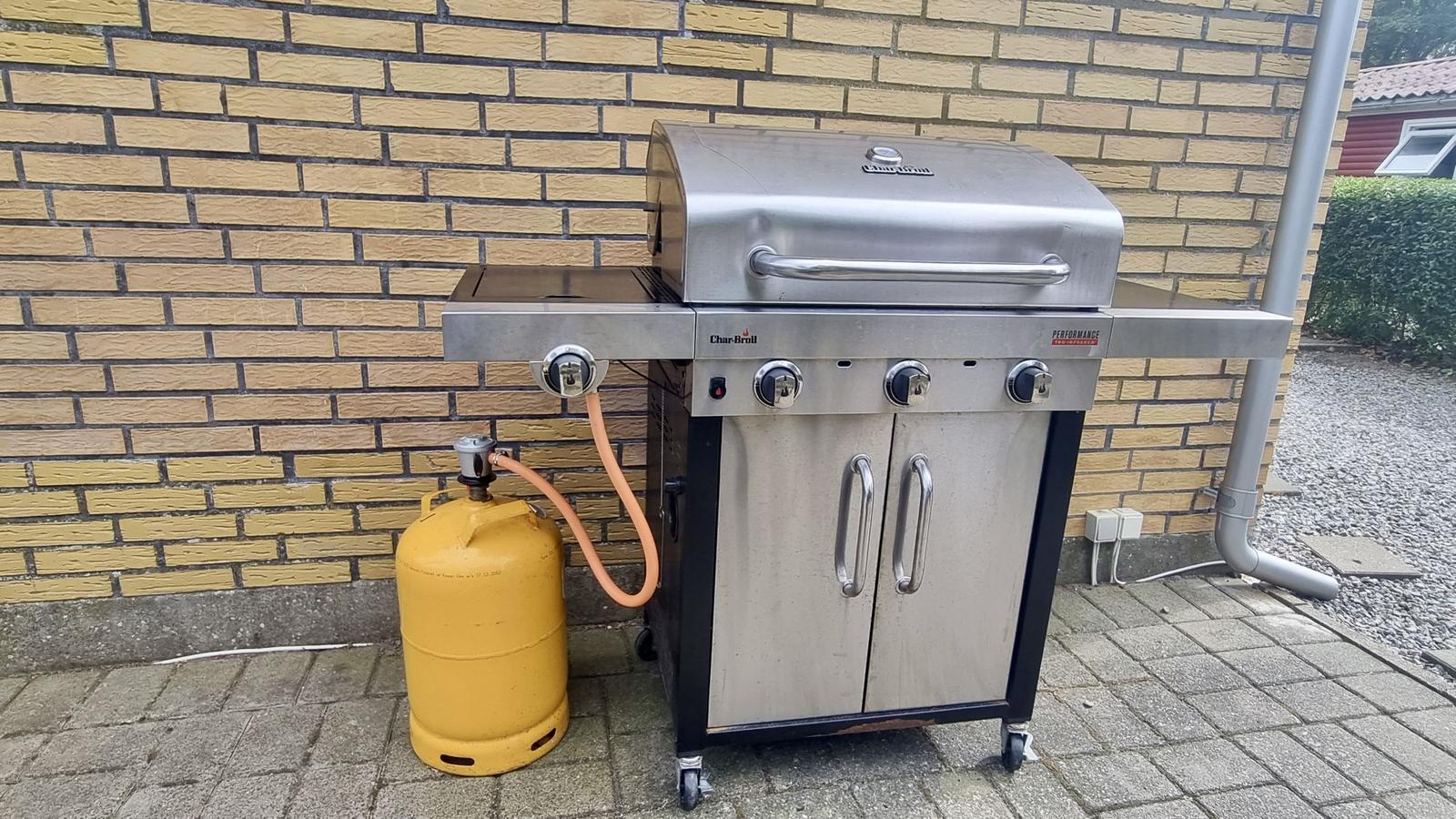 Gasherd mit Gasflasche auf Terrasse vor Backsteinwand