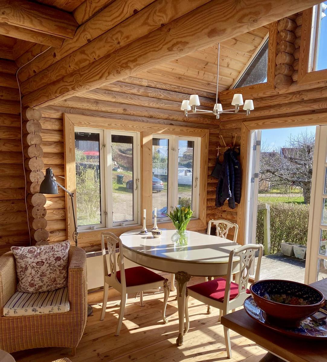 Esszimmer mit Holzdecke, Tisch und Stühlen, Fenster und Terrassentür.