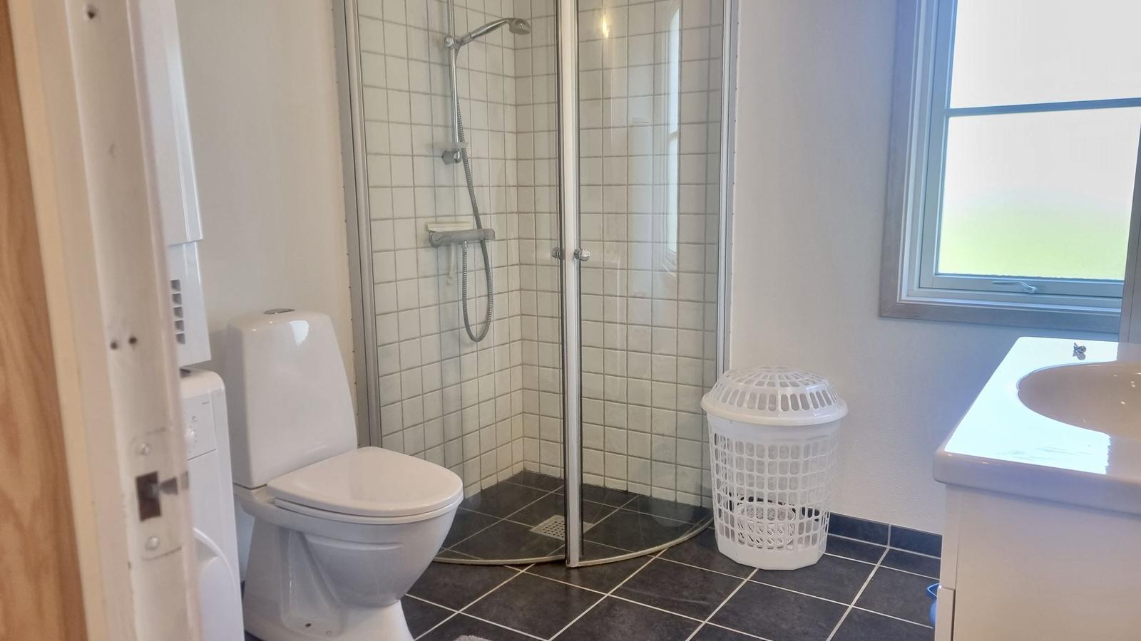Badezimmer mit Dusche, Toilette und Waschbecken