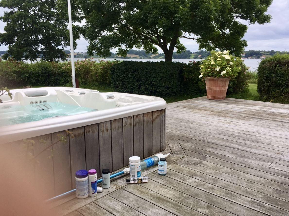Hochwertige Whirlpool-Terrasse mit Blick auf Wasser und Bäume