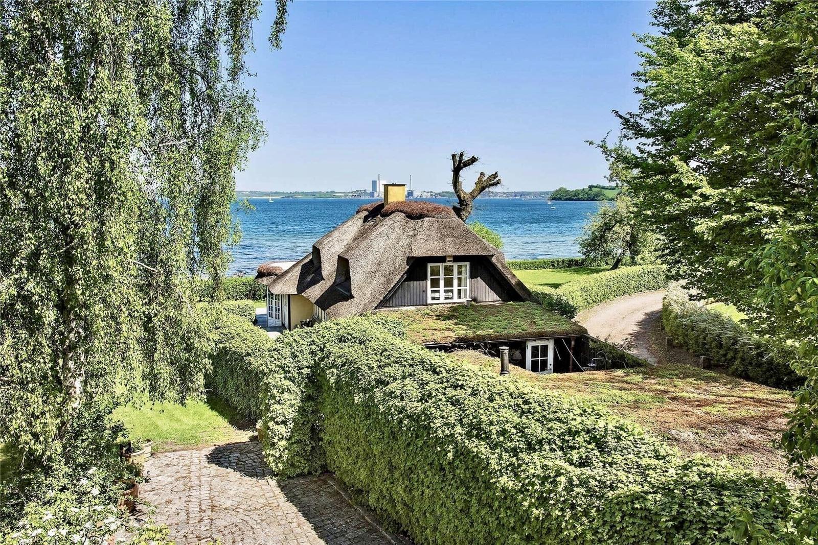 Haus mit Strohdach und Blick auf Wasser