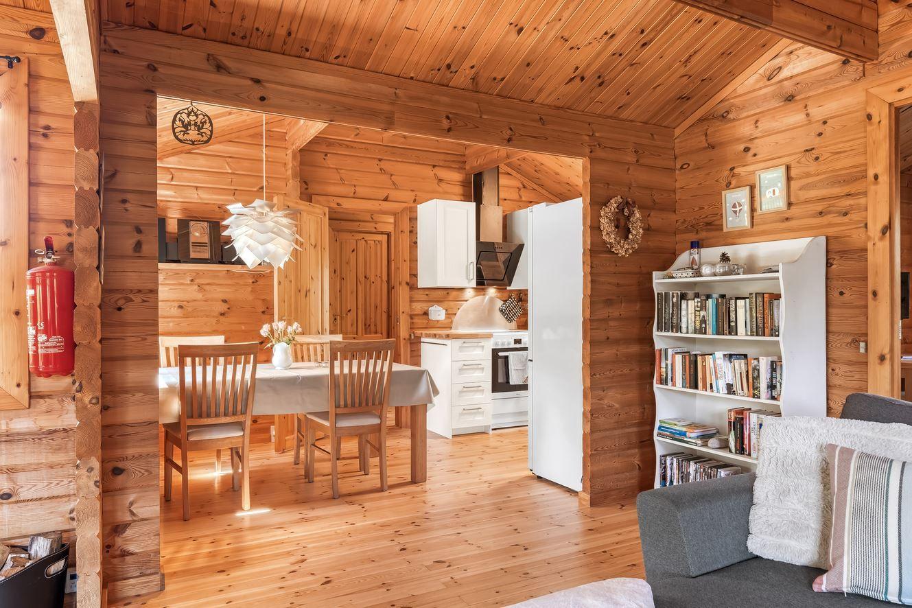 Wohn- und Essbereich mit Küche und Bücherregal in Holzhaus