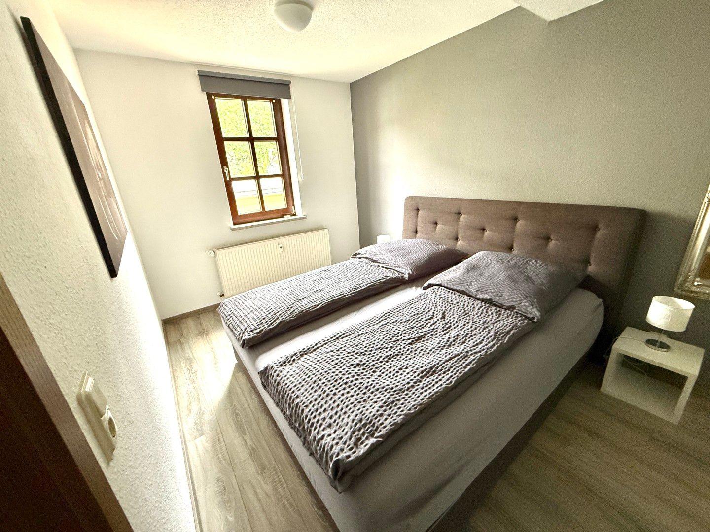 Ruhiges Schlafzimmer mit Boxspringbett in der Ferienwohnung Harztraum an der alten Stadtmauer in Blankenburg