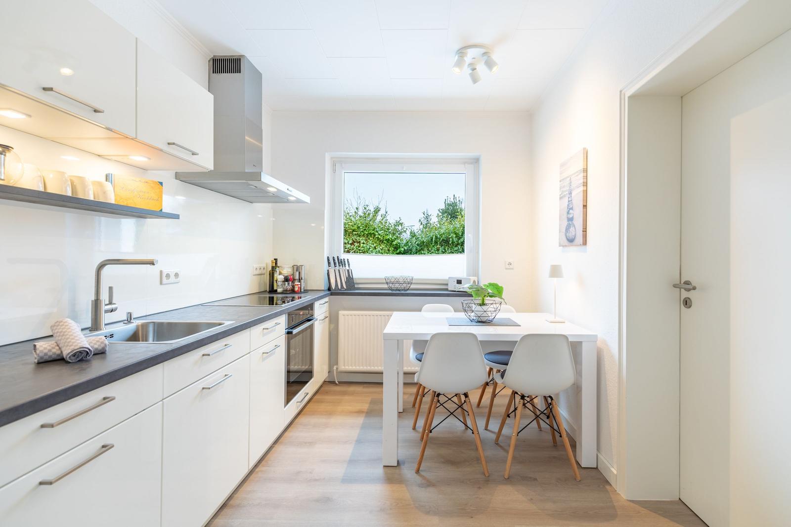 Küche mit Essbereich, Fenster und moderner Einrichtung.