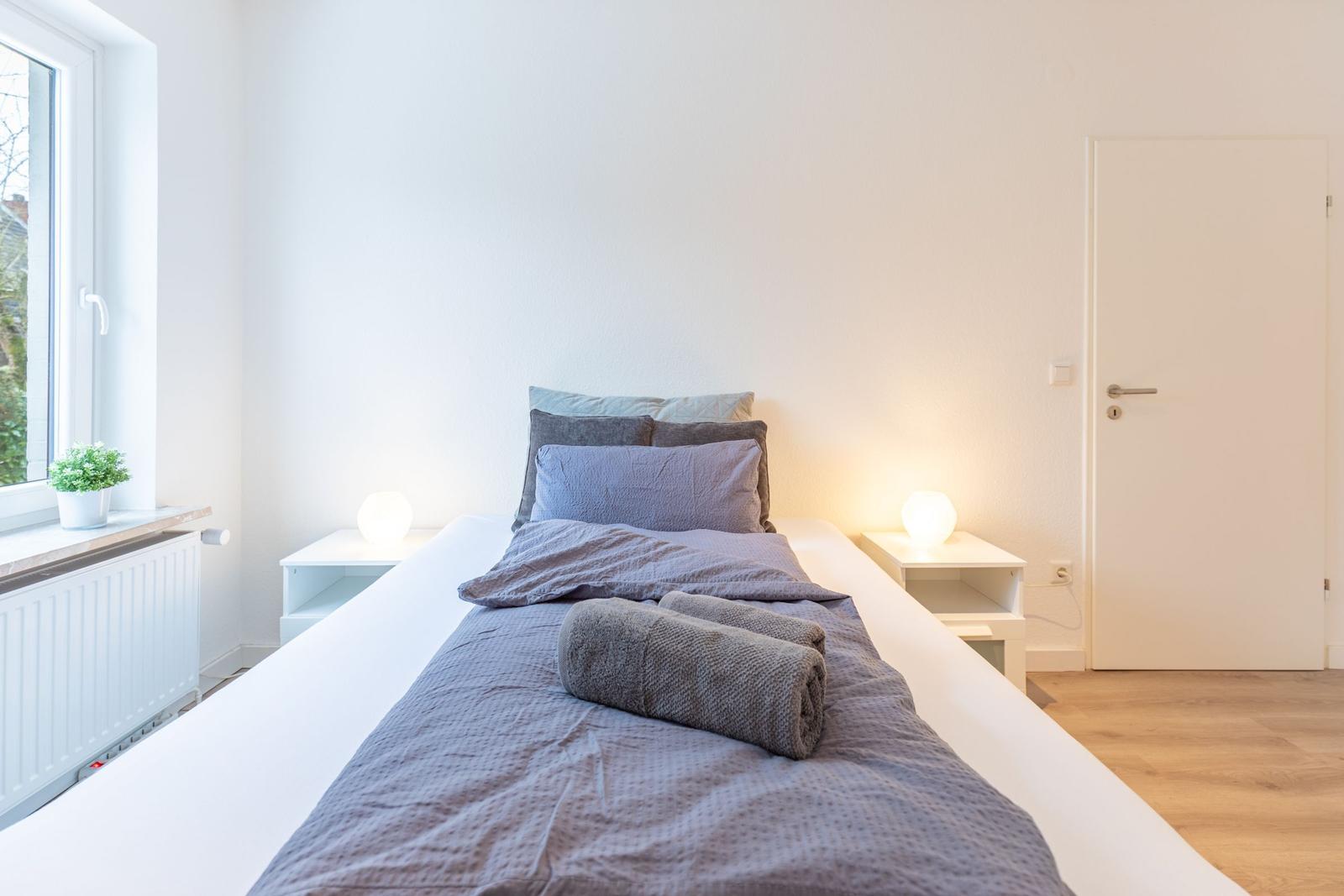 Schlafzimmer mit Bett, Nachttischen und Fenster