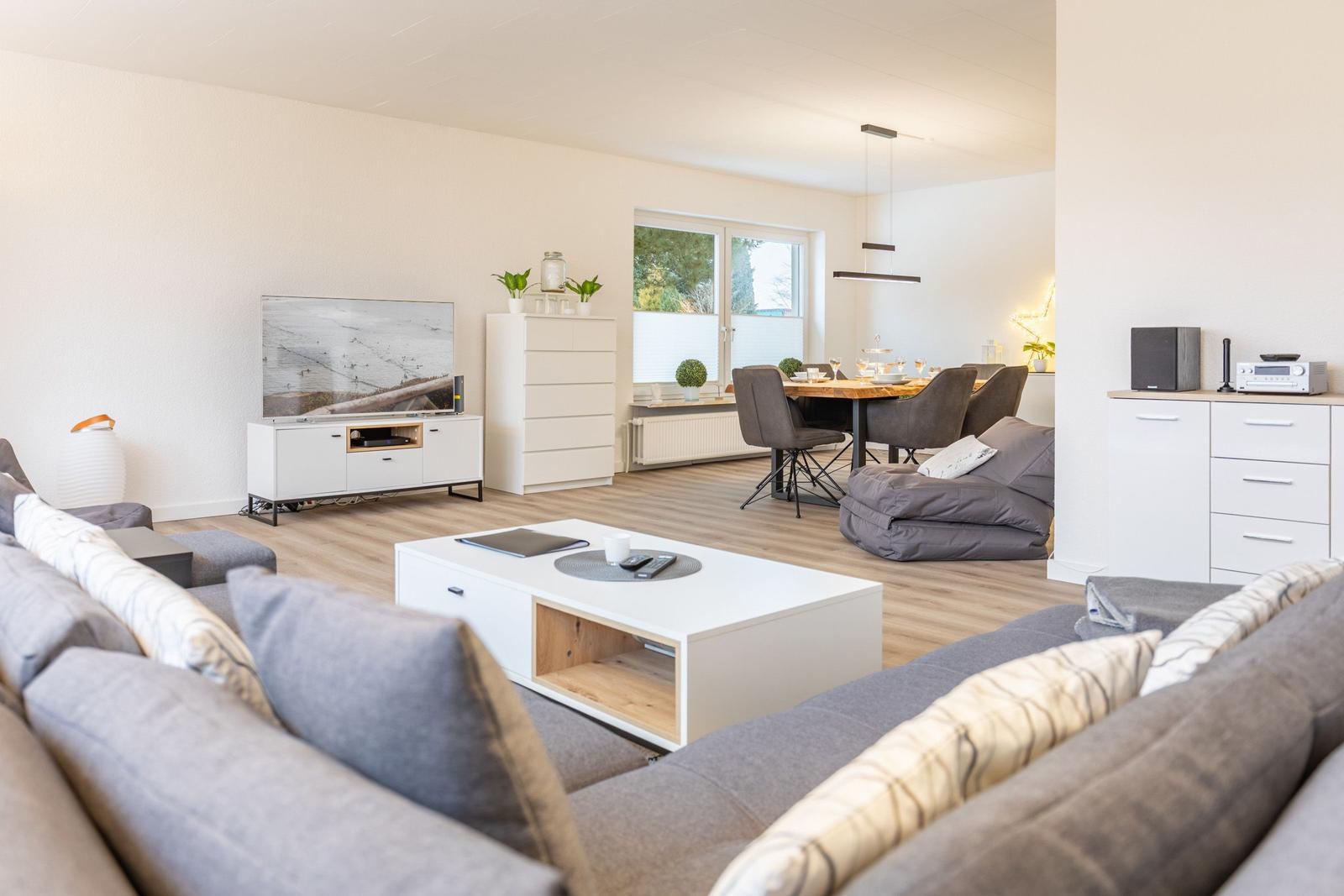 Wohn- und Essbereich mit Sofa, Couchtisch und Fernseher.