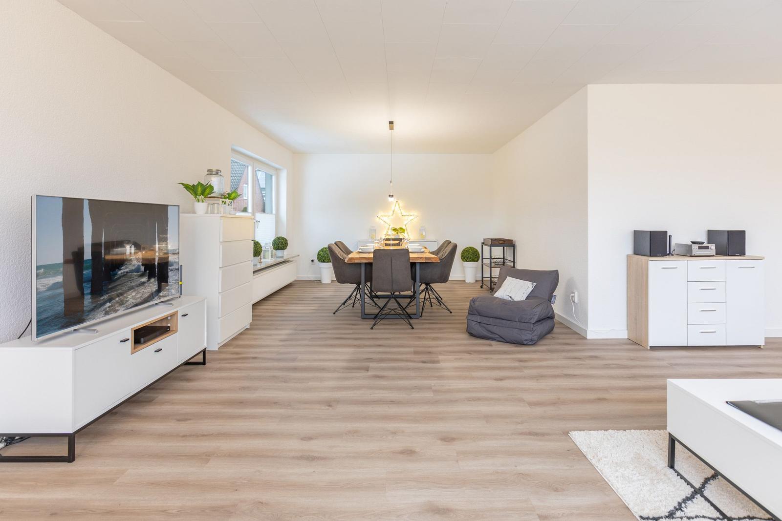 Wohn- und Essbereich mit Fernseher, Esstisch und Sitzgelegenheiten.