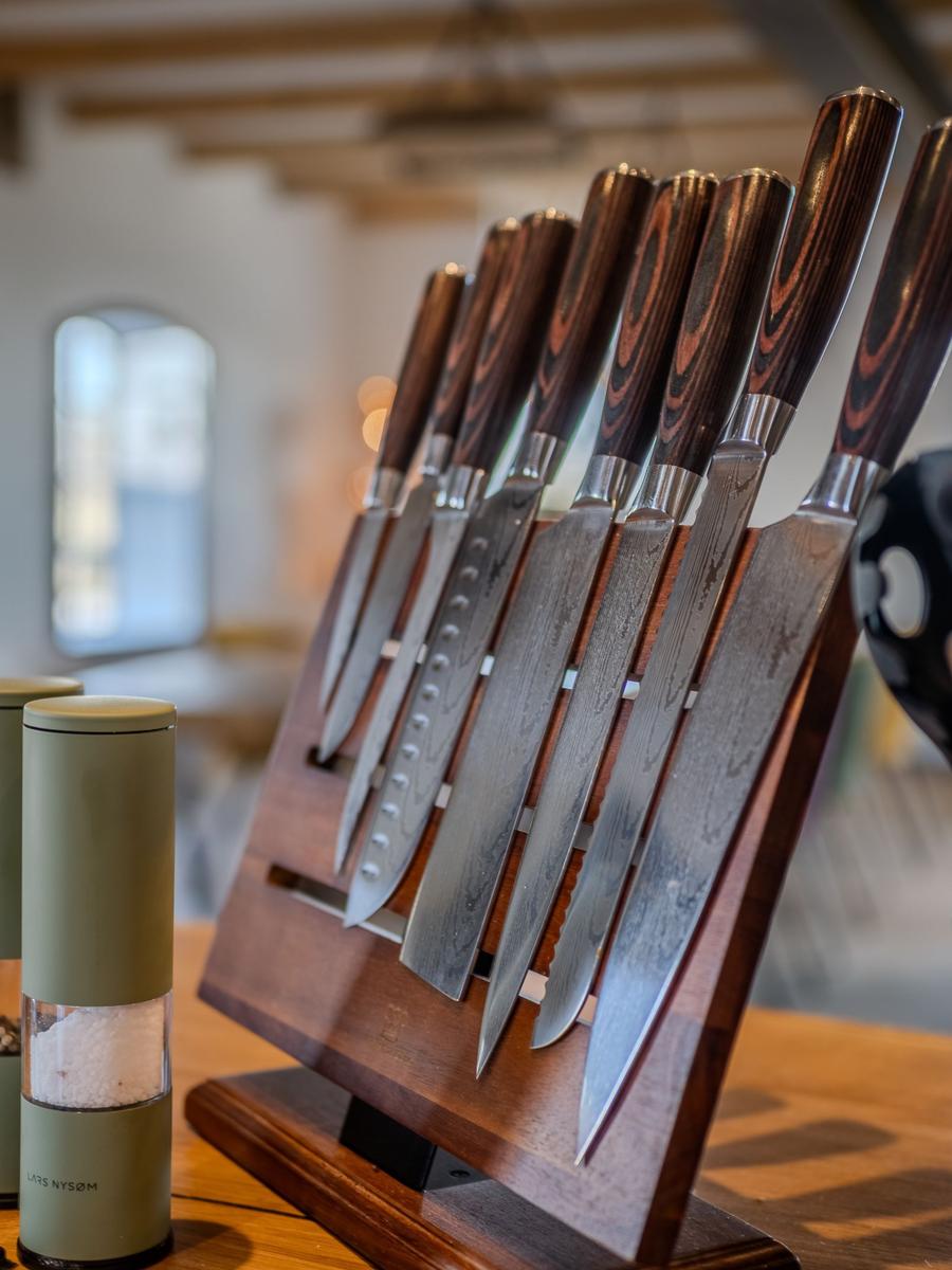 Küchenmesser mit Holzgriffen in einem Holzhalter auf Tisch