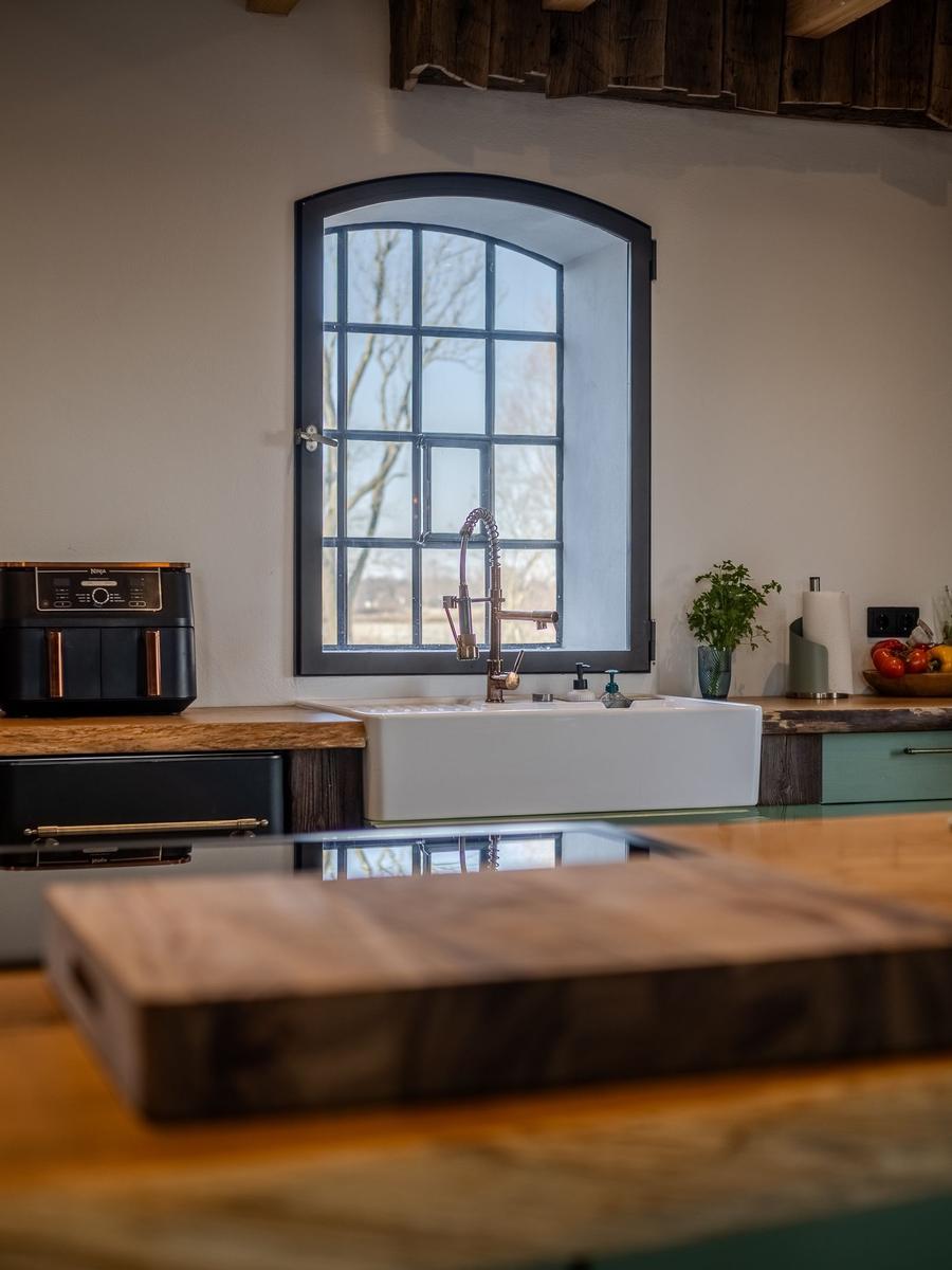 Küche mit Waschbecken, Fenster und Holzoberflächen