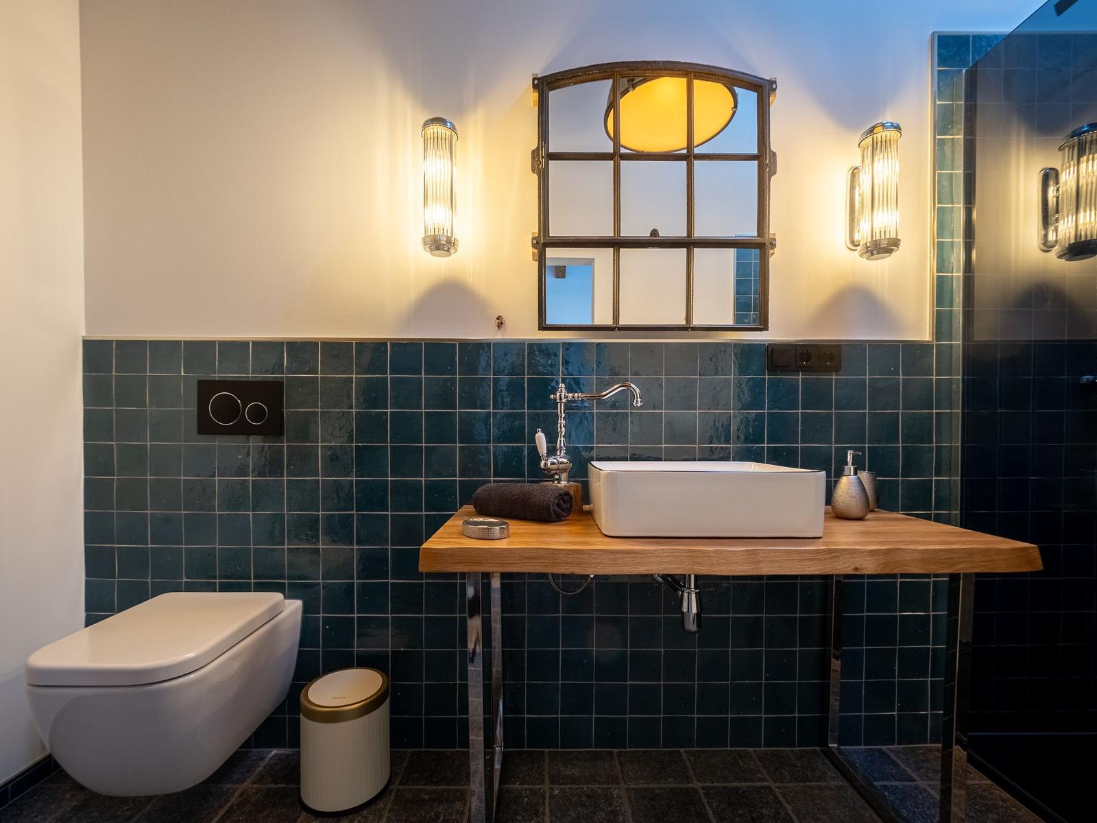 Bad mit Waschtisch auf Holz, Toilette und Spiegel mit Fensterform.